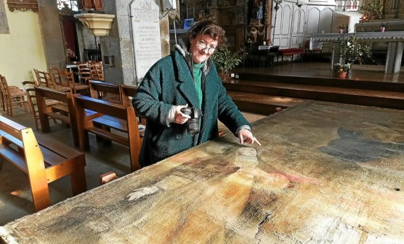 La restauratrice Catherine Ruel examine le grand tableau du Rosaire qui part en Vendée pour être restauré.